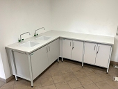 Stół laboratoryjny przyścienny kątowy w kształcie litery L z dwoma zlewami ceramicznymi..